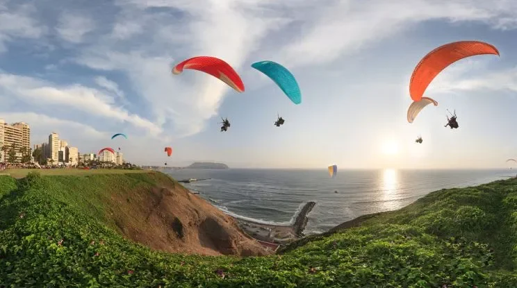 Tandem paragliding over Lima’s Costa Verde cliffs with Pacific Ocean views and Miraflores skyline
