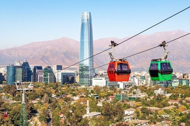 Panoramic view of Santiago de Chile with iconic landmarks and the Andes mountains.